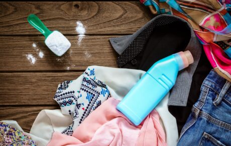 Dirty clothes with detergent and bleach nearby